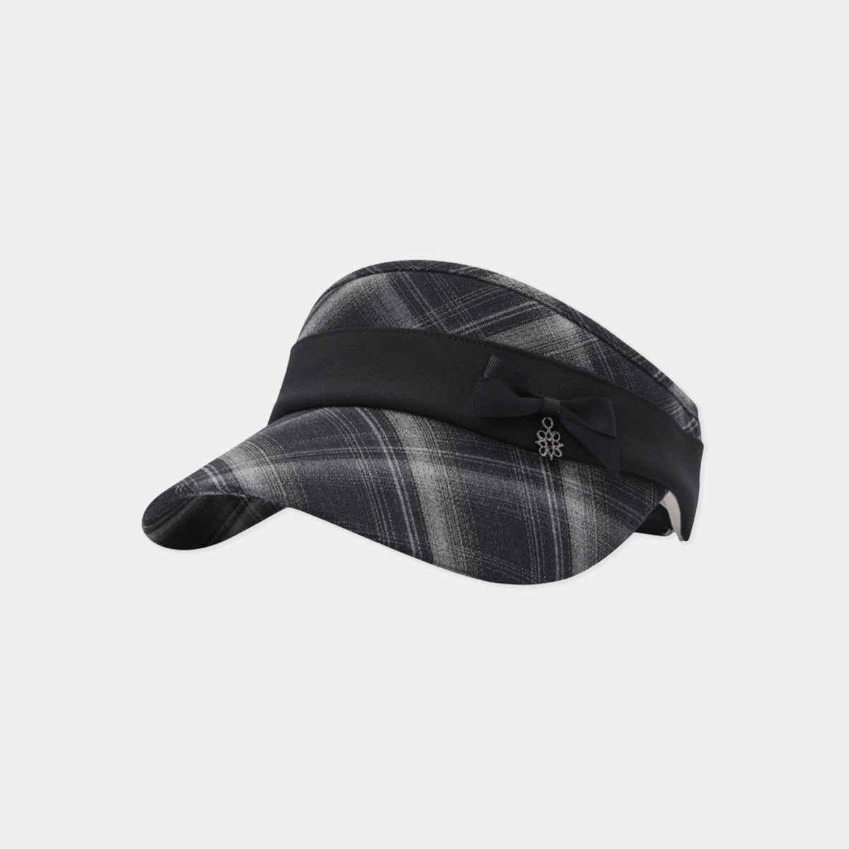 A women's visor hat featuring a dark gray and black plaid pattern on the crown and brim, accented by a wide black band with a small black bow and silver floral emblem on the side.