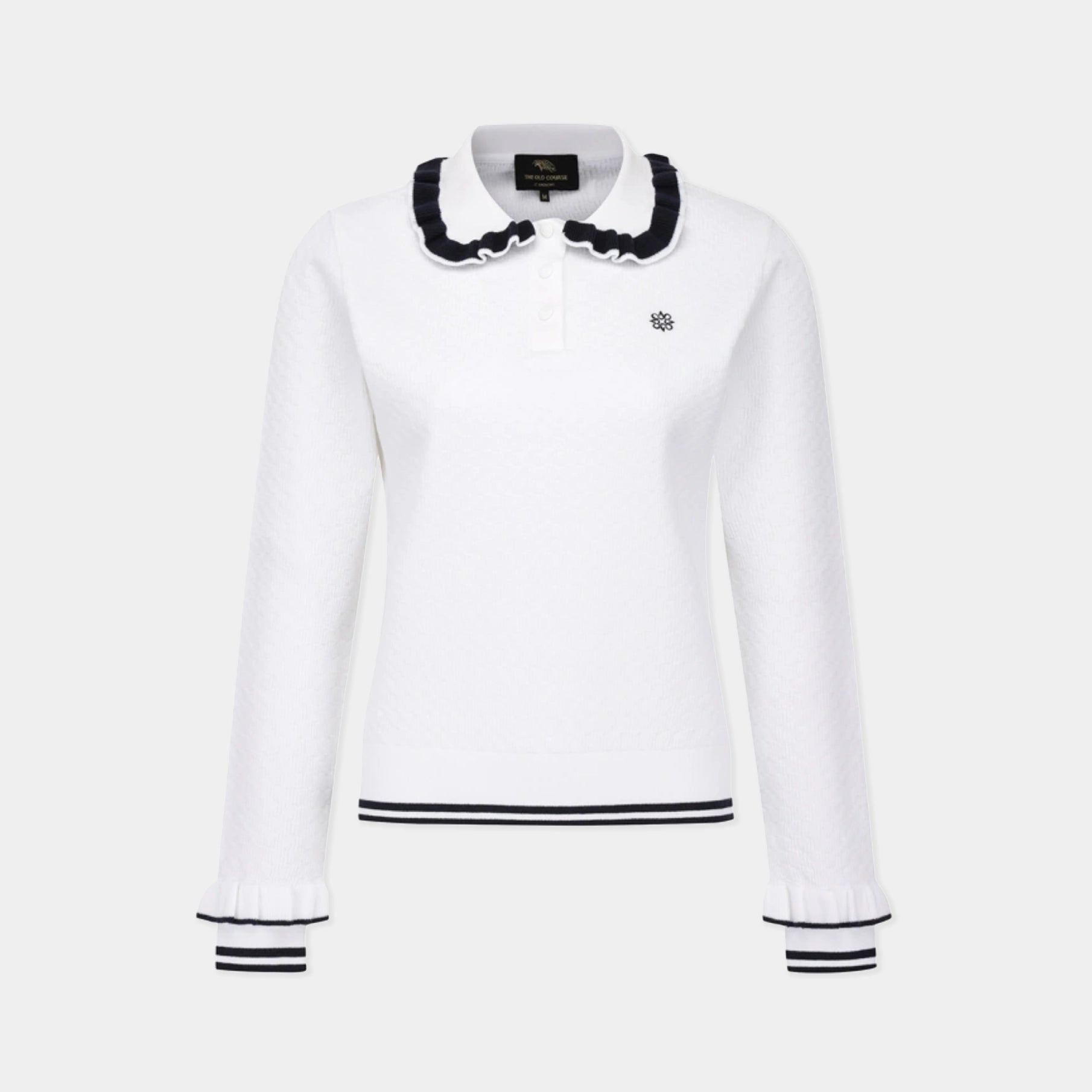 A white long-sleeve knit polo-style top with a ruffled black-and-white collar, black horizontal trim at the hem, and black-and-white striped cuffs, shown on a light gray background.