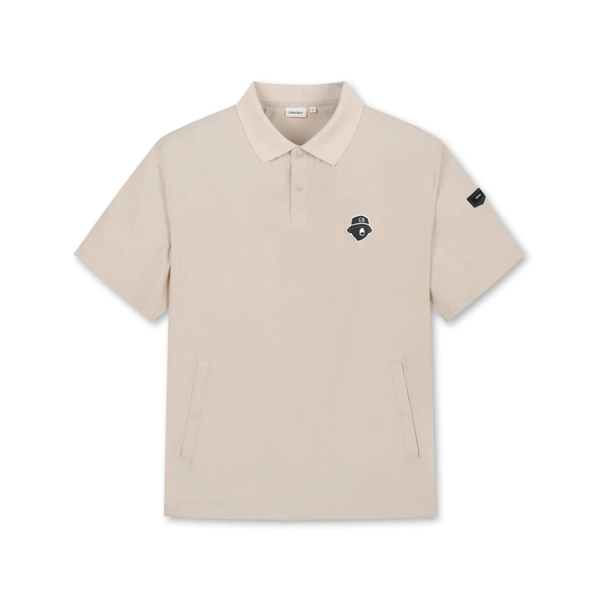 A beige short-sleeve polo shirt with a small black embroidered logo on the left chest and a black sleeve patch, displayed on a clean white background.