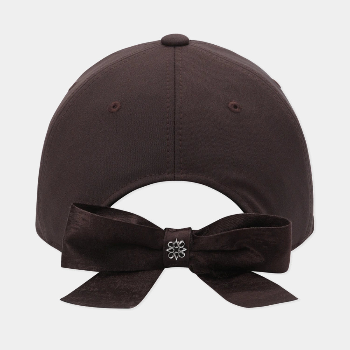 A dark brown baseball cap shown from the back, featuring a matching dark brown fabric bow with a small silver flower-shaped center accent, set against a light gray background.