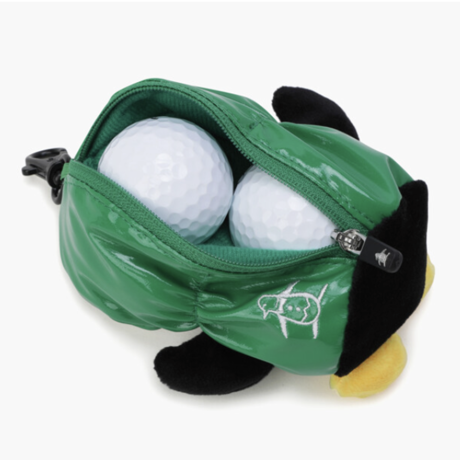 A green plush golf ball bag shaped like a penguin, shown open with two white golf balls inside. The bag has black plush feet, a yellow beak, and a white embroidered logo on the front.