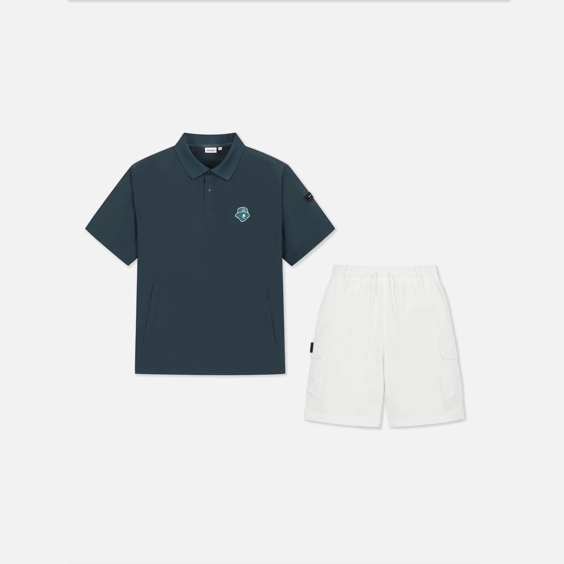 A two-piece adult' outfit set featuring a short-sleeve polo shirt in dark slate blue with a small circular chest logo, paired with white cargo shorts, displayed on a clean light gray background.