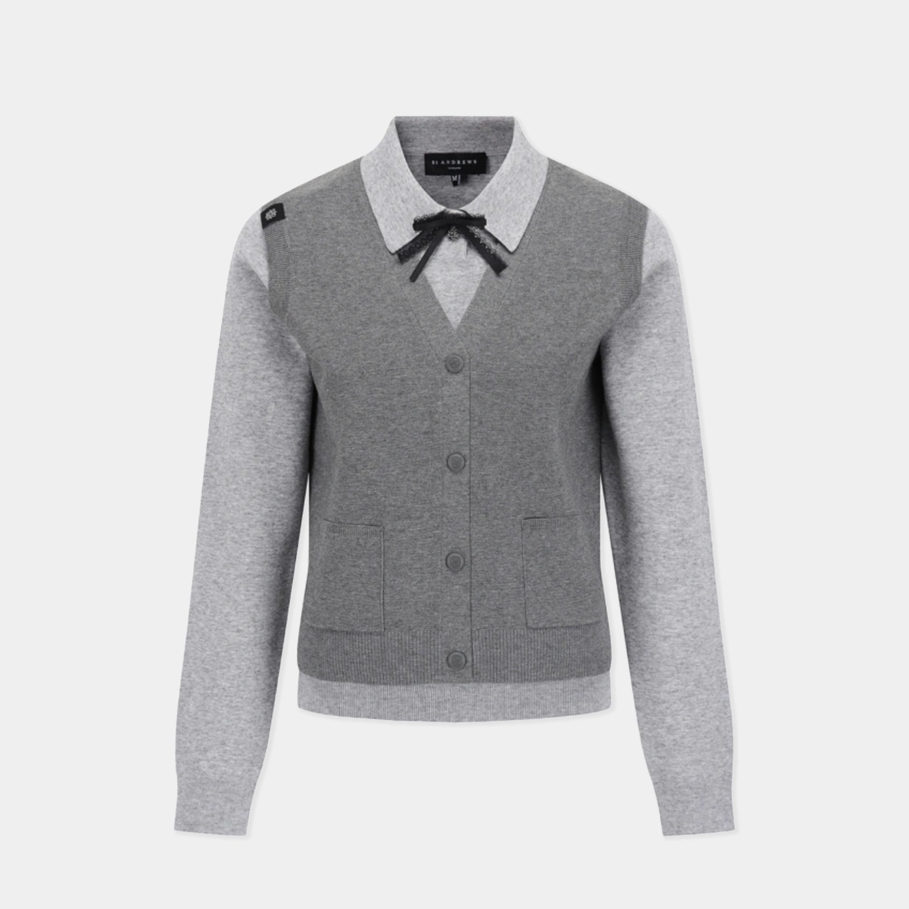 A gray and light gray color-blocked cardigan sweater with a black bow at the collar, shown on a light gray background.
