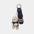 A St Andrews collegiate-themed keychain featuring a plush teddy bear in a navy sweater next to a miniature navy sock with yellow stripes and a metal split ring.