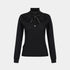 A black long-sleeve knit top with a high mock neck, featuring a layered ruffled collar with a black bow accent and a small silver floral brooch at the center, shown against a light gray background.