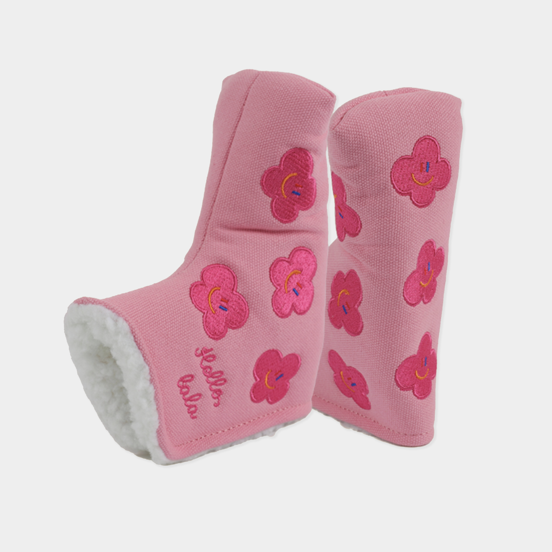 Pink head covers with embroidered smiling pink flowers and white sherpa lining, shown on a light gray background.