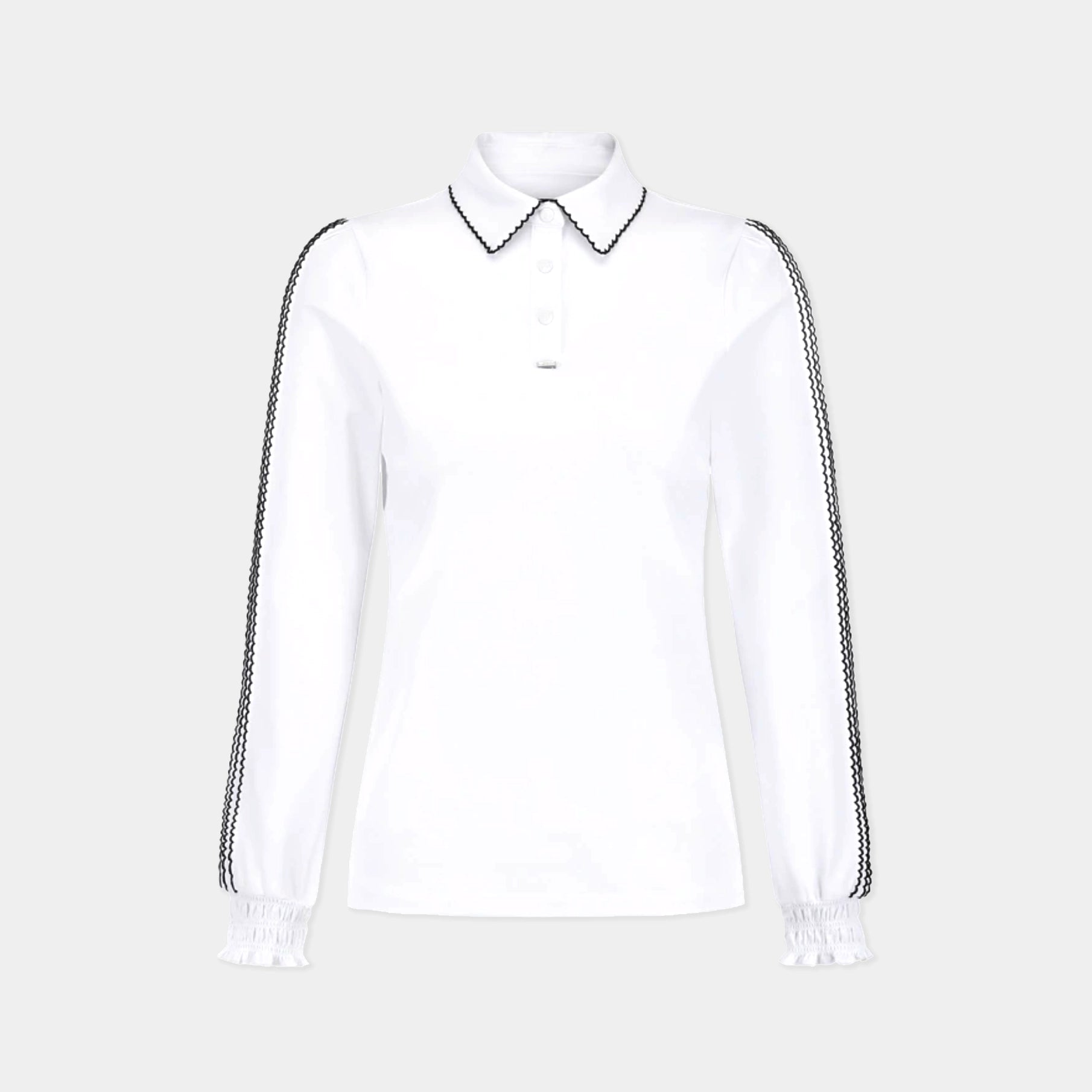 A white long-sleeve polo shirt with black-and-white patterned trim on the collar and down the sleeves, featuring a buttoned placket and elasticized cuffs, shown against a light gray background.