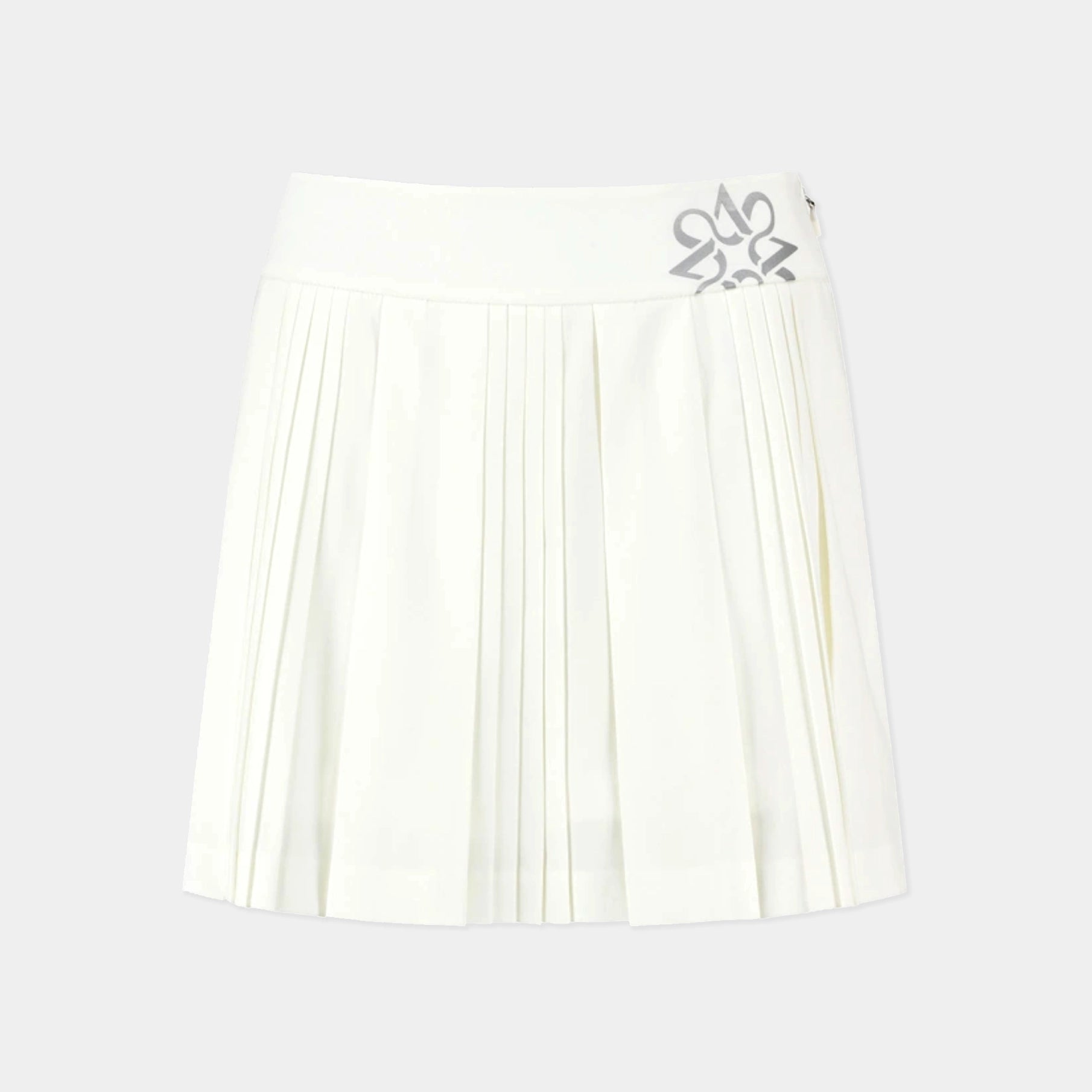 An off-white pleated tennis skirt with a wide waistband and a silver metallic butterfly emblem on the right side, shown against a light gray background.