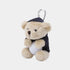 A plush teddy bear keychain or bag charm with a silver carabiner. The bear is beige with a dark navy blue hat and sweater, holding a white golf ball.