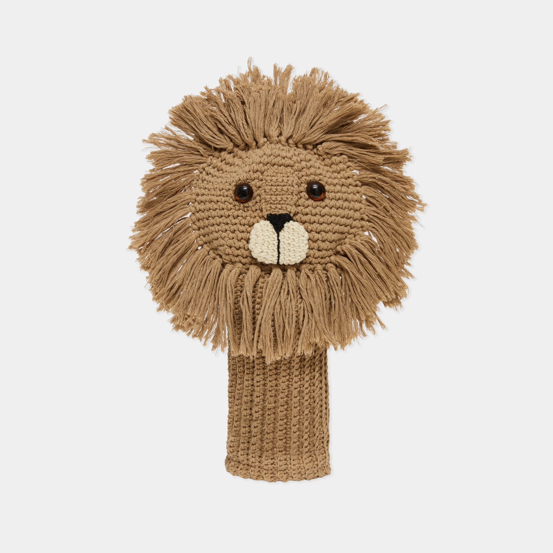 A hand-knitted lion head golf club cover in shades of tan and brown, featuring a textured mane, embroidered facial features, and a knitted neck sleeve, shown against a plain light gray background.