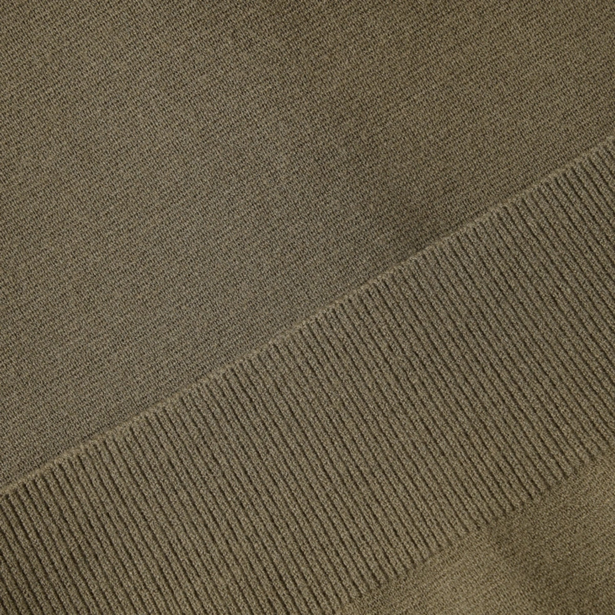 Close-up of a ribbed knit fabric in a muted taupe-brown color, showing the texture and stitch detail.