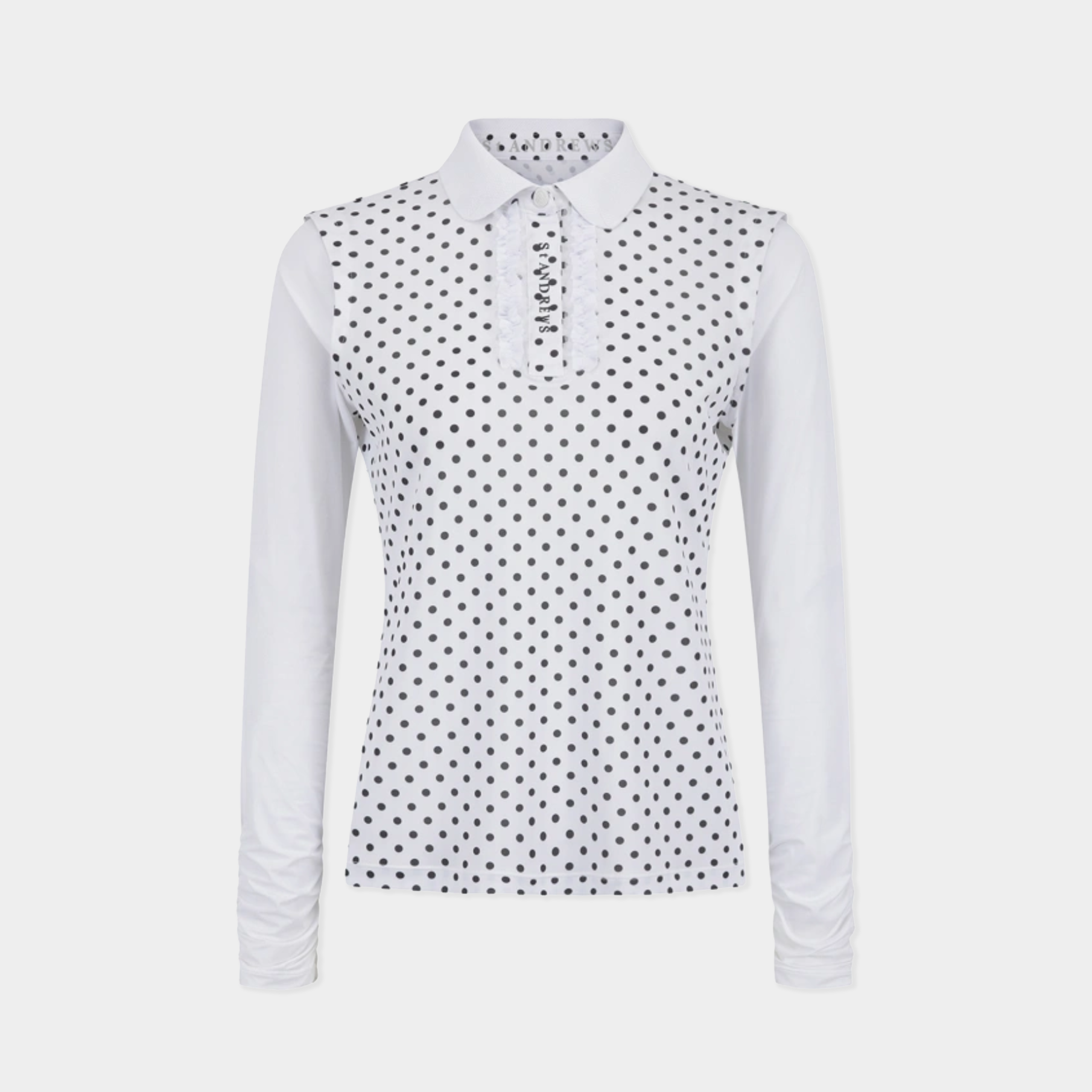 A women's long-sleeve polo shirt in white with a black polka dot pattern across the body and collar, shown on a light gray background.