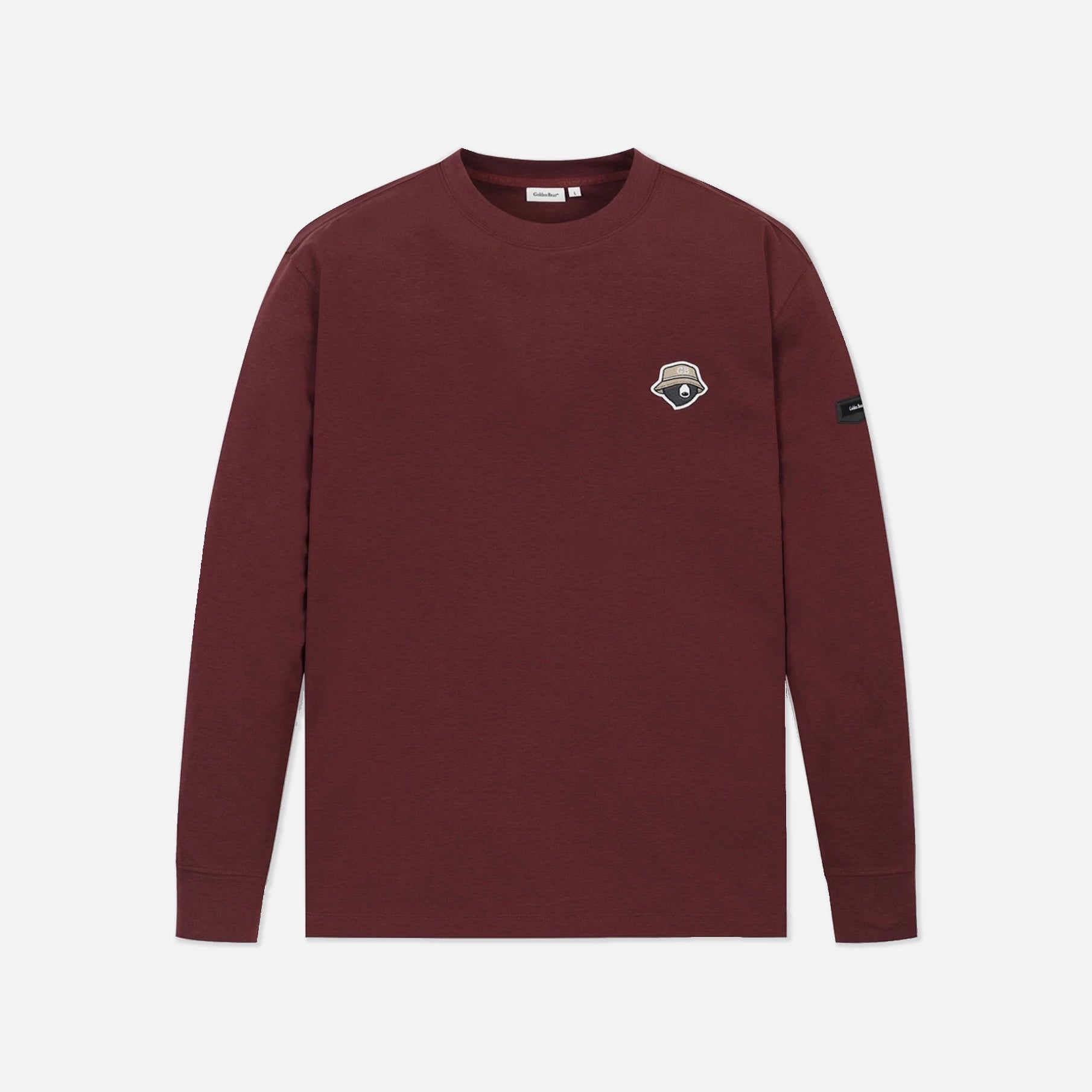 A long-sleeve crewneck shirt in maroon, featuring a small embroidered shield logo on the left chest and a black brand tag on the right sleeve, displayed against a light gray background.