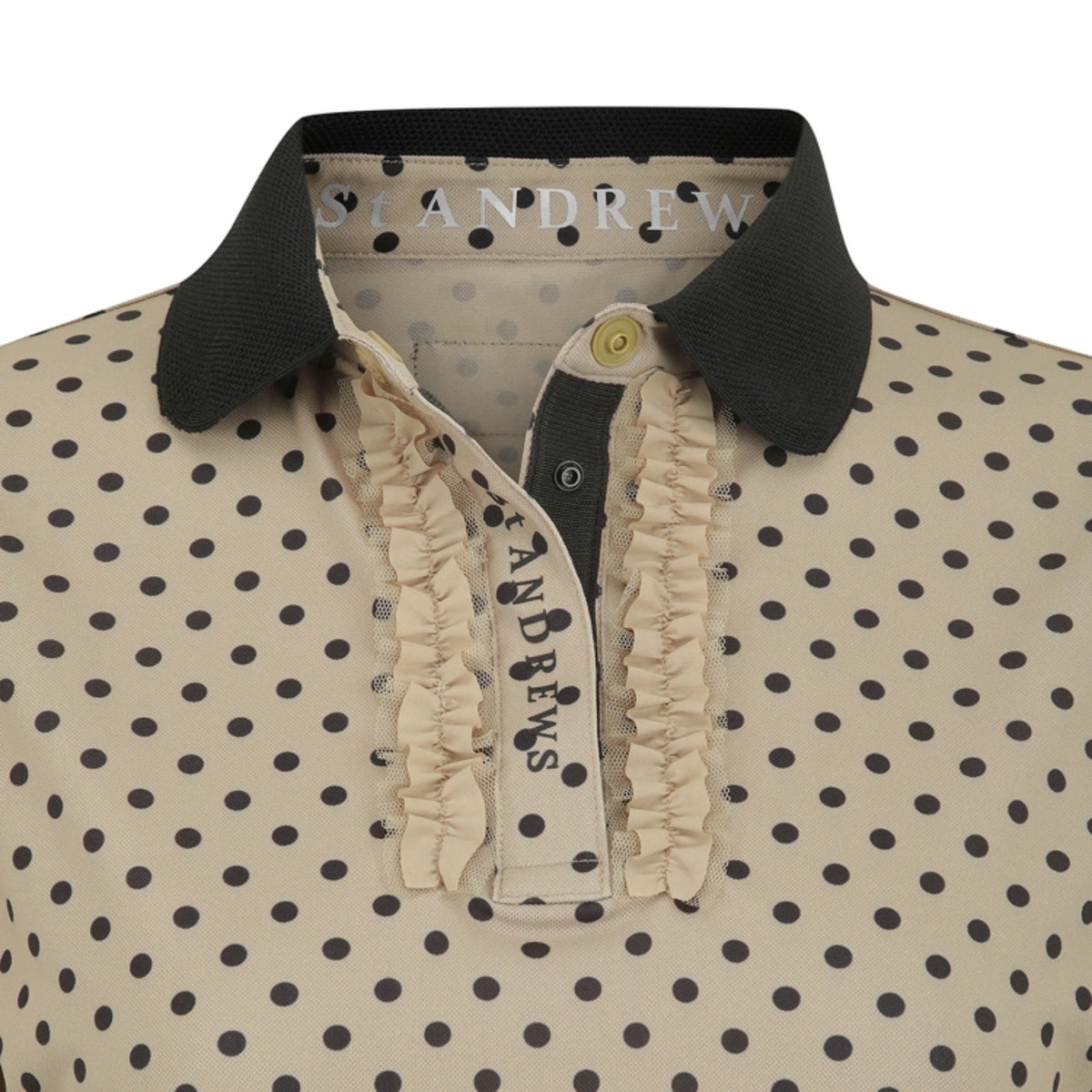 Close-up of a St. Andrew polo shirt featuring a beige and black polka dot pattern, a black ribbed collar, and a ruffled cream placket.
