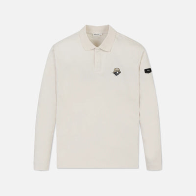 An off-white long-sleeve polo shirt with a small embroidered shield logo on the left chest and a black brand patch on the right sleeve, shown against a light gray background.