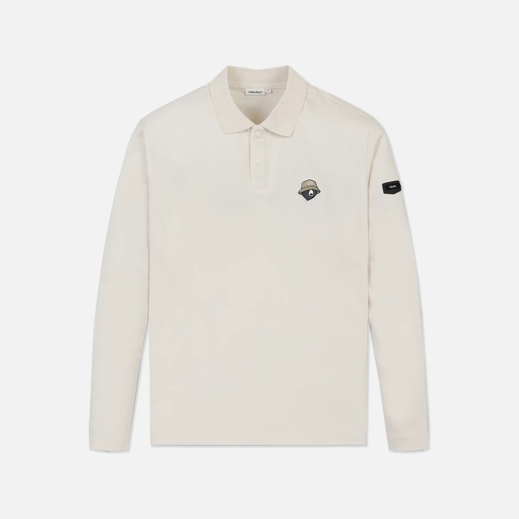 An off-white long-sleeve polo shirt with a small embroidered shield logo on the left chest and a black brand patch on the right sleeve, shown against a light gray background.
