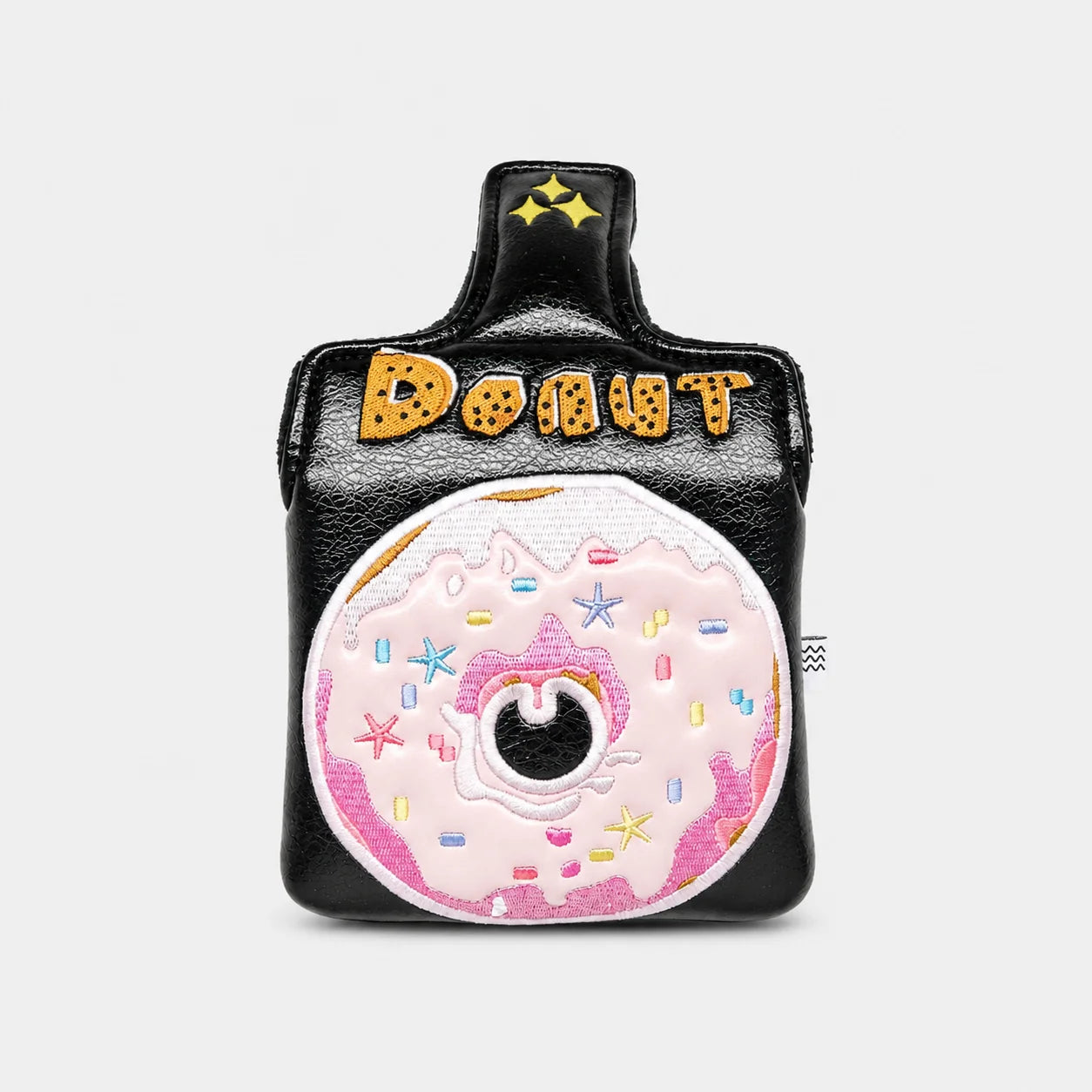 A black faux-leather mallet putter cover designed like a coffee cup, featuring a large pink donut with sprinkles on the front and the word 'DONUT' in gold letters on the handle.