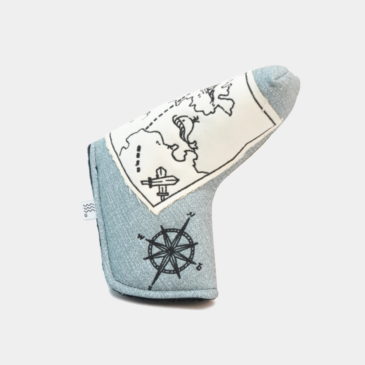 A light blue denim golf club headcover with a cream-colored map print, featuring black line drawings of a compass rose and a ship's wheel.