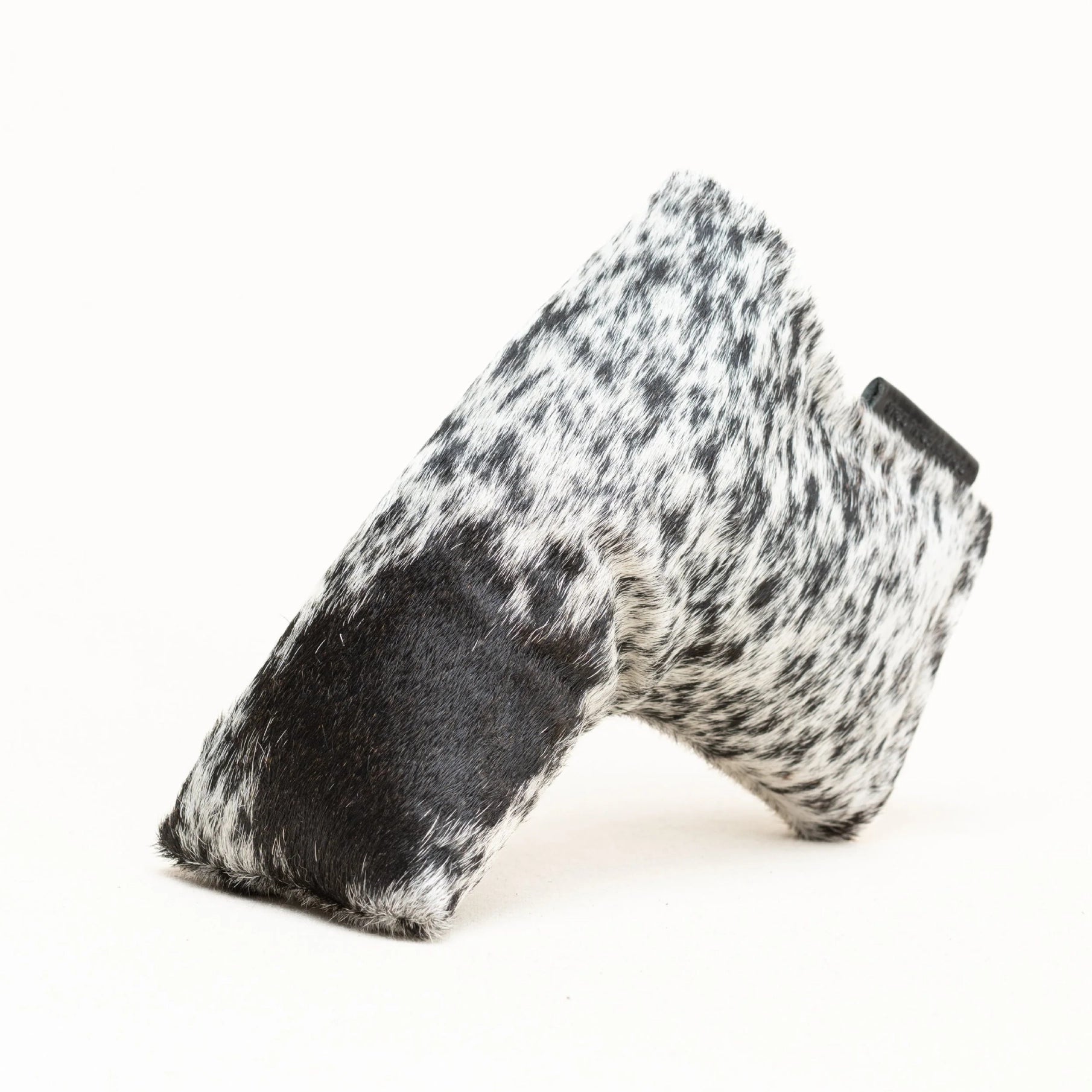 A black and white speckled faux fur putter cover with a solid black leather-like patch, photographed on a clean white background.