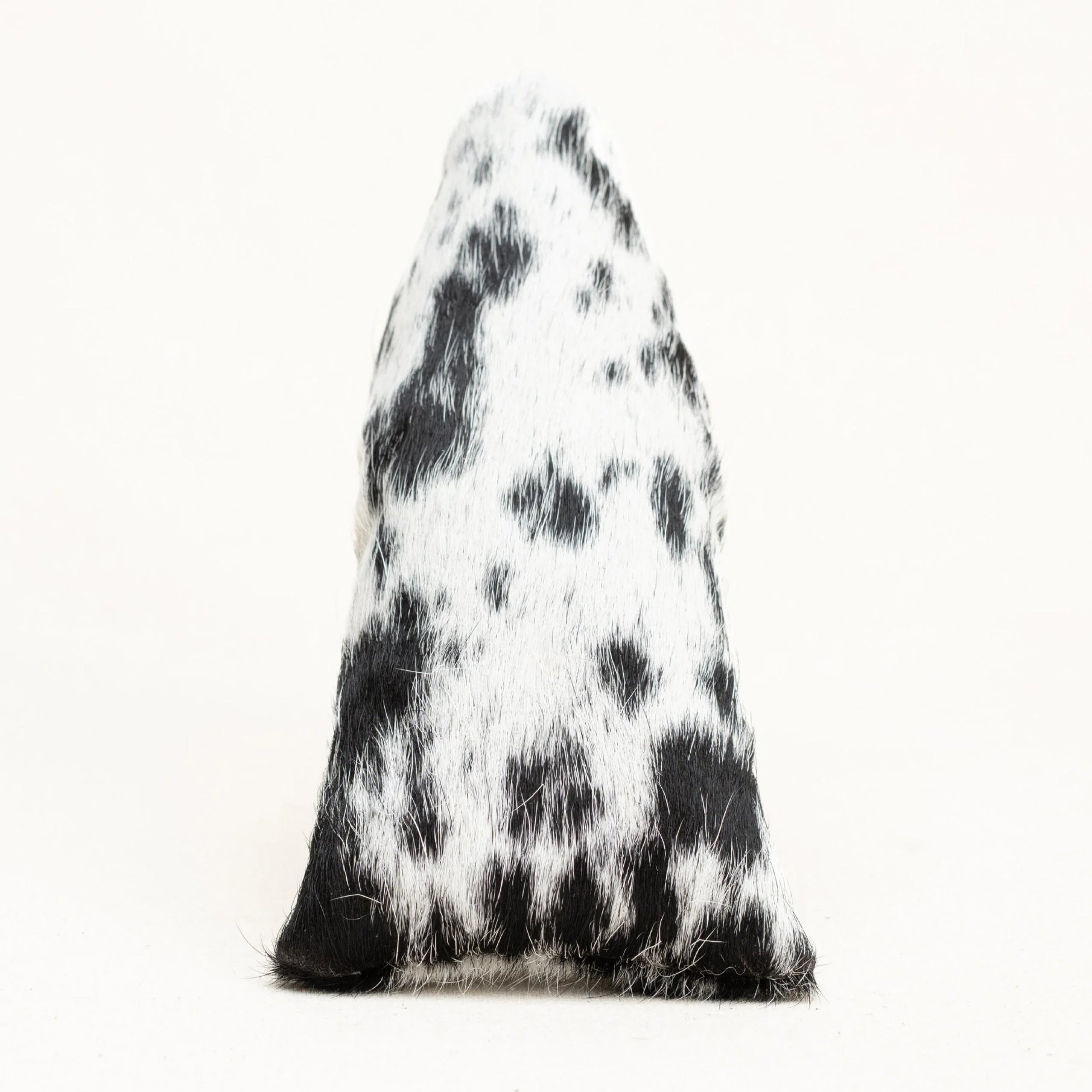 A putter cover with a black and white cowhide pattern, photographed against a plain white background.