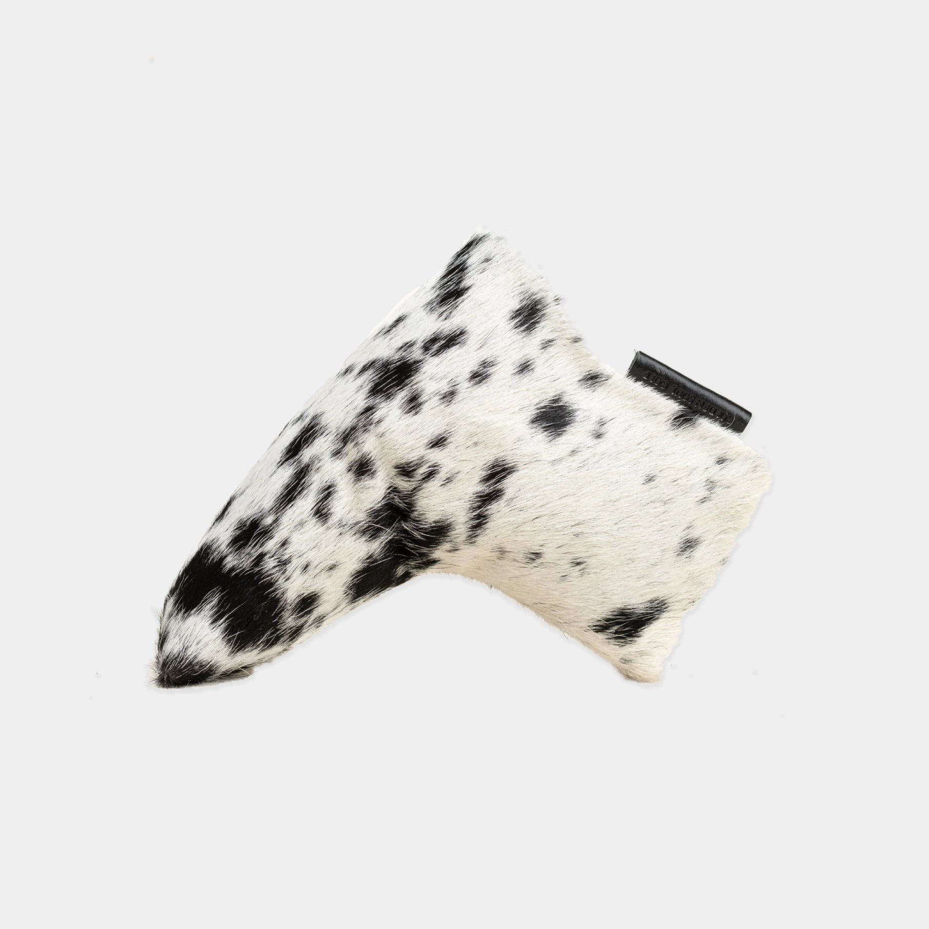 A cowhide golf putter cover with a black and white speckled pattern, shown on a light gray background.