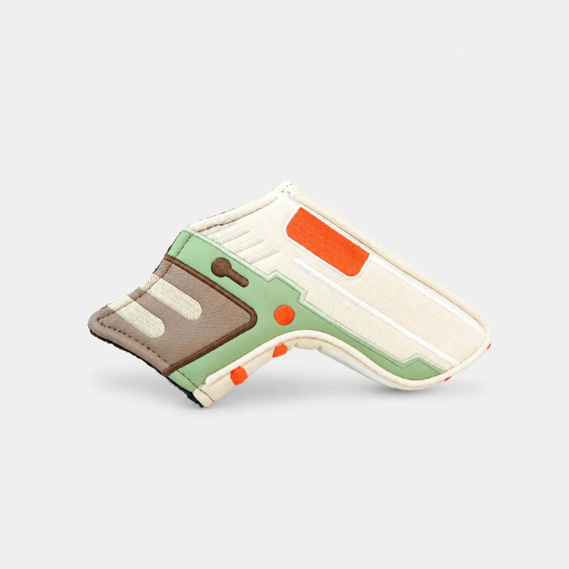 A miniature replica of a sci-fi blaster pistol, styled with light green, off-white, brown, and orange panels, displayed on a clean light gray background.