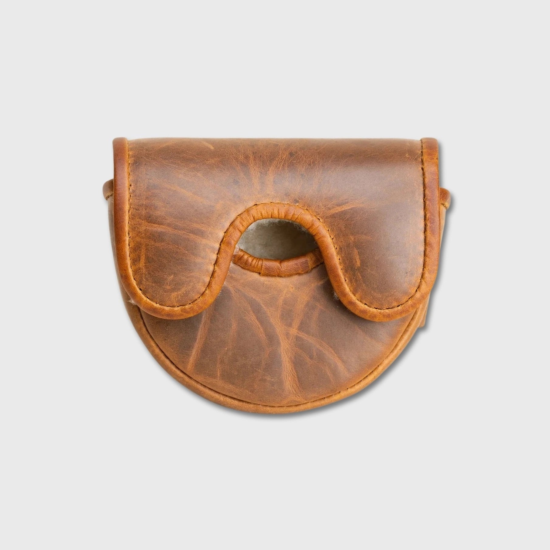 A small brown leather OZ1 putter cover with a curved flap and central cutout, photographed on a plain light gray background.