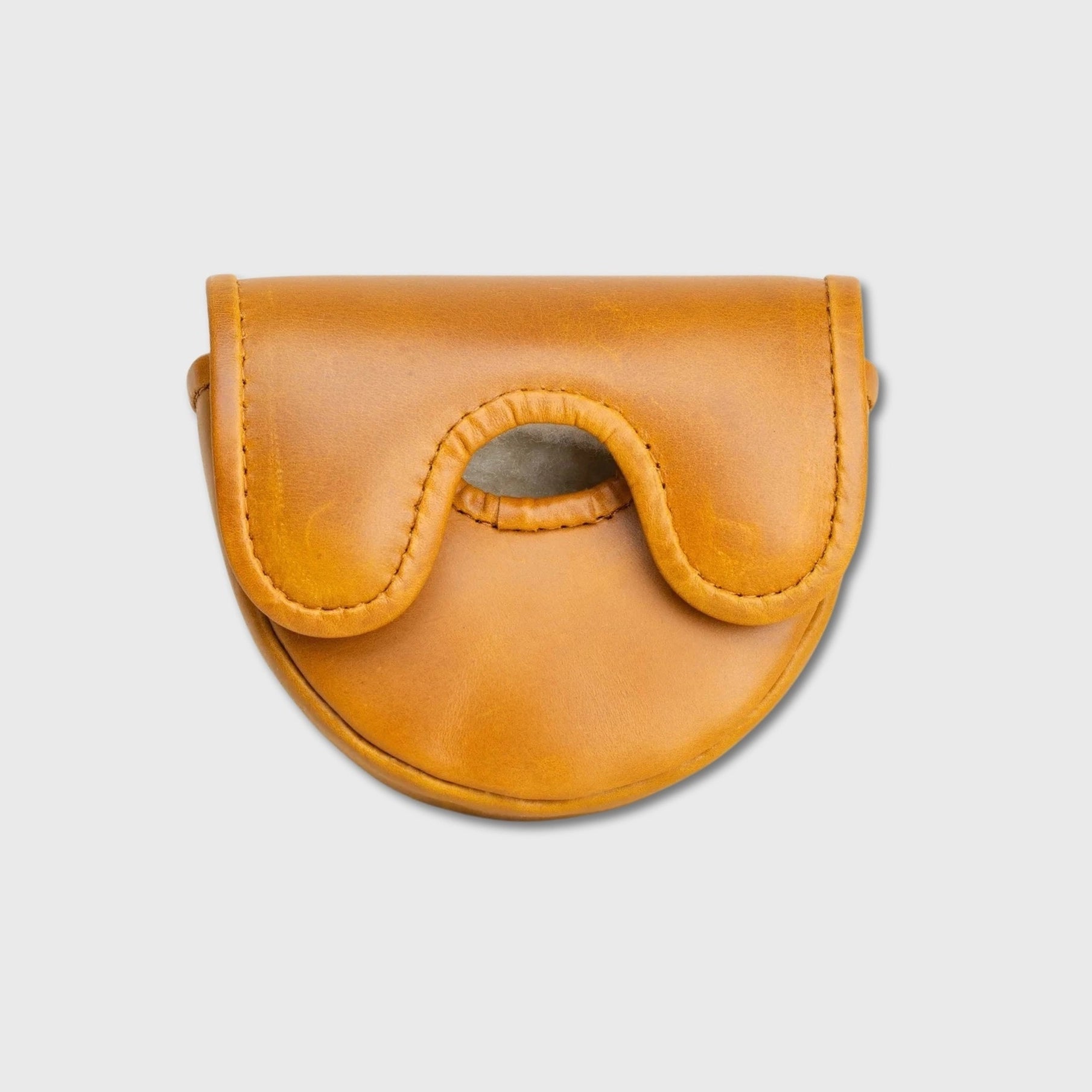 A small tan leather OZ1 putter cover with a curved flap and a central cutout, photographed on a plain light gray background.