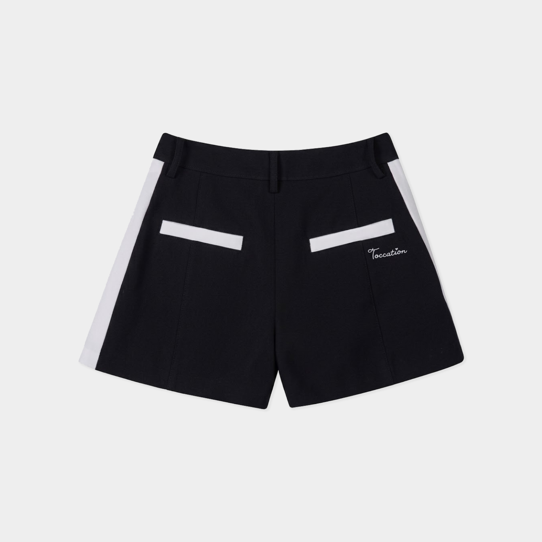 Black shorts with white side panels and white rectangular accents on the back pockets, featuring a small white script logo on the left pocket, shown against a light gray background.