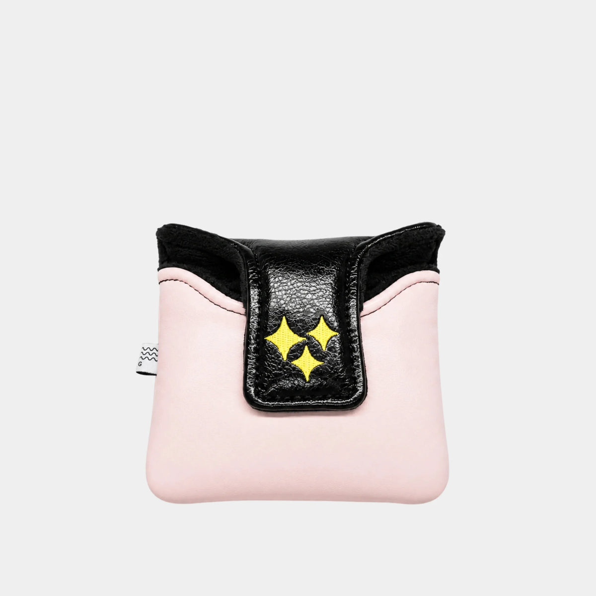 A pink mallet putter cover with a black flap featuring three yellow star-like cutouts, photographed against a light gray background.