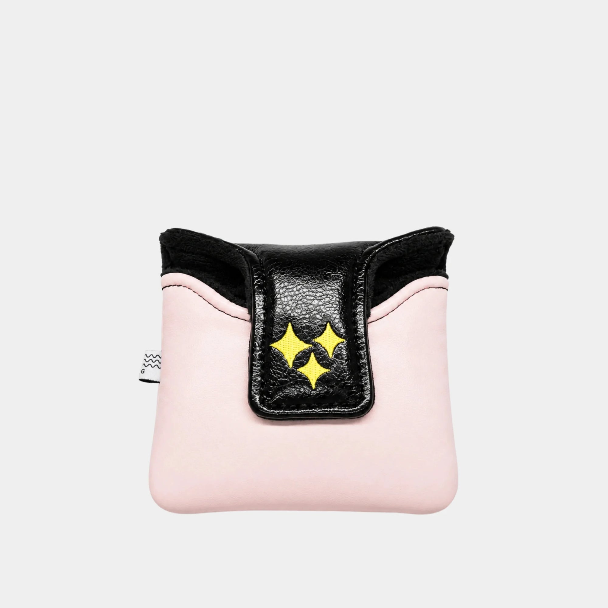 A pink mallet putter cover with a black flap featuring three yellow star-like cutouts, photographed against a light gray background.