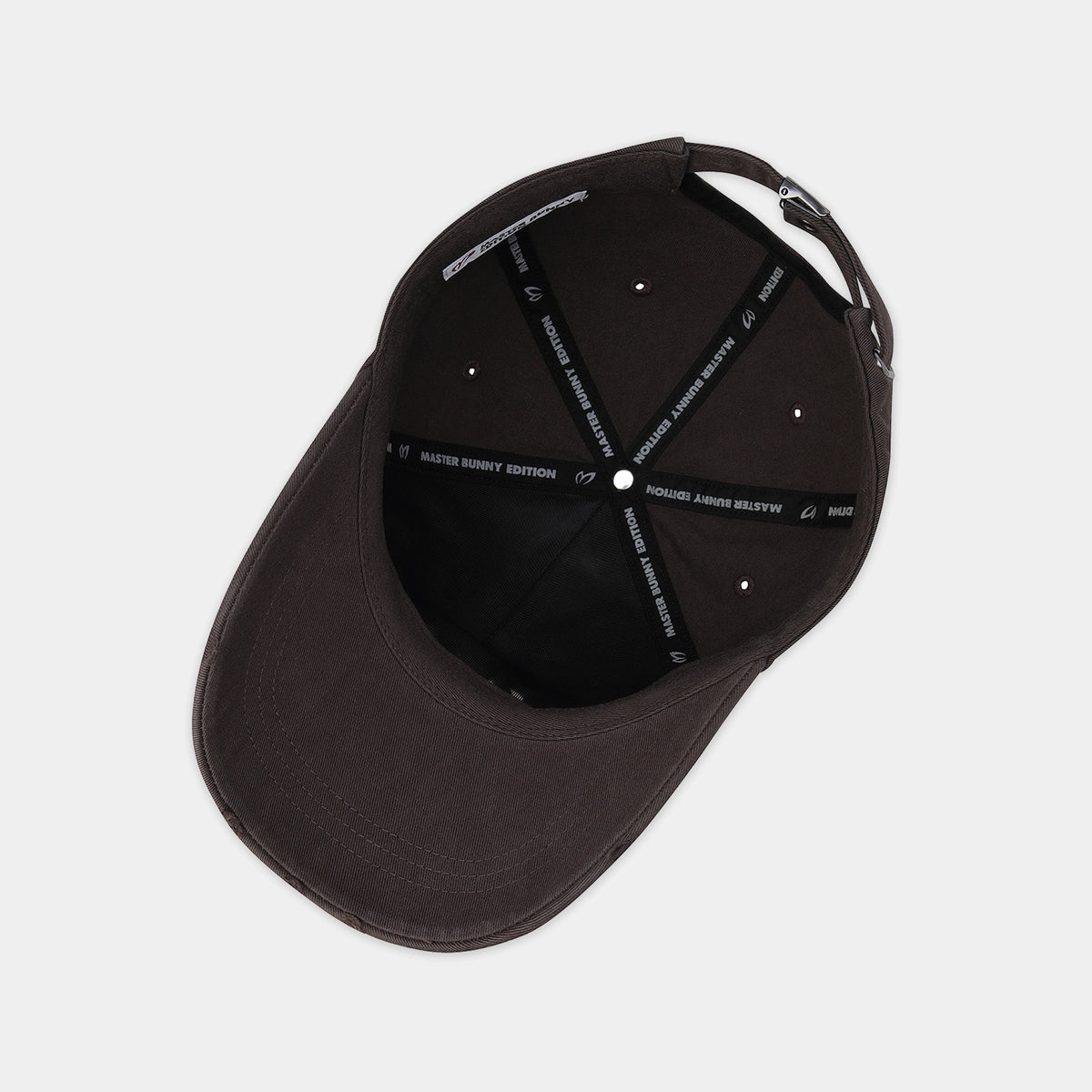 A dark brown structured baseball cap shown from a top-down angle, revealing the black interior with white embroidered text on the support straps.