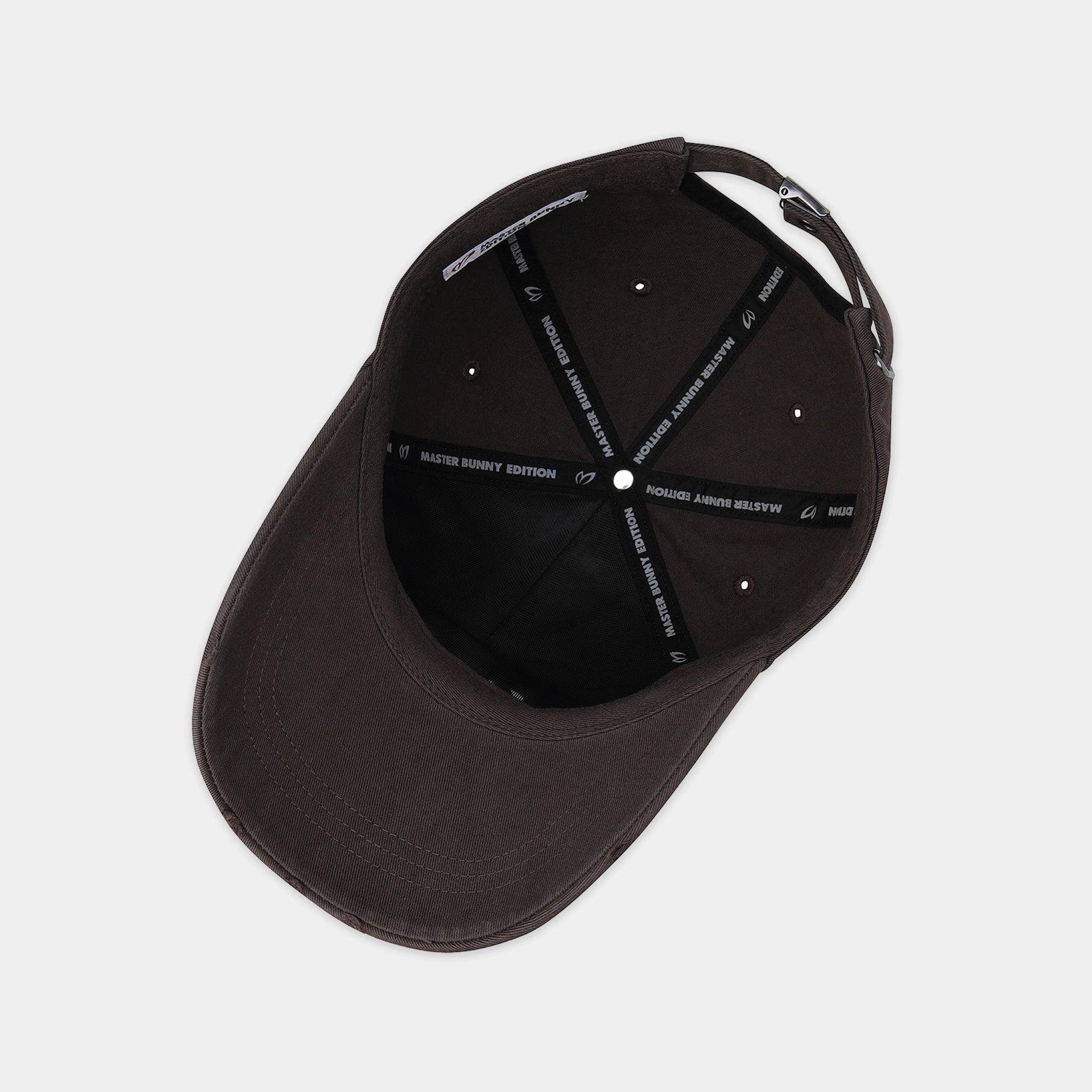 A dark brown structured baseball cap shown from a top-down angle, revealing the black interior with white embroidered text on the support straps.