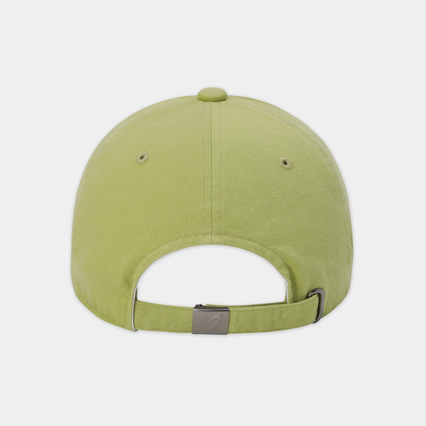 The back view of a light olive green baseball cap with an adjustable strap and a small metallic brand logo on the buckle, set against a plain light gray background.