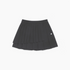 A black pleated mini skirt with a small white embroidered logo on the left side, displayed flat against a light gray background.