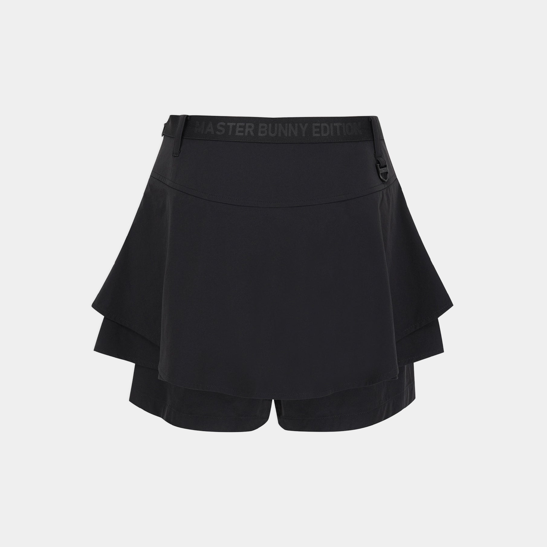 A black athletic mini skirt with a layered ruffle design and a wide elastic waistband featuring the text 'MASTER BUNNY EDITION', shown against a light gray background.