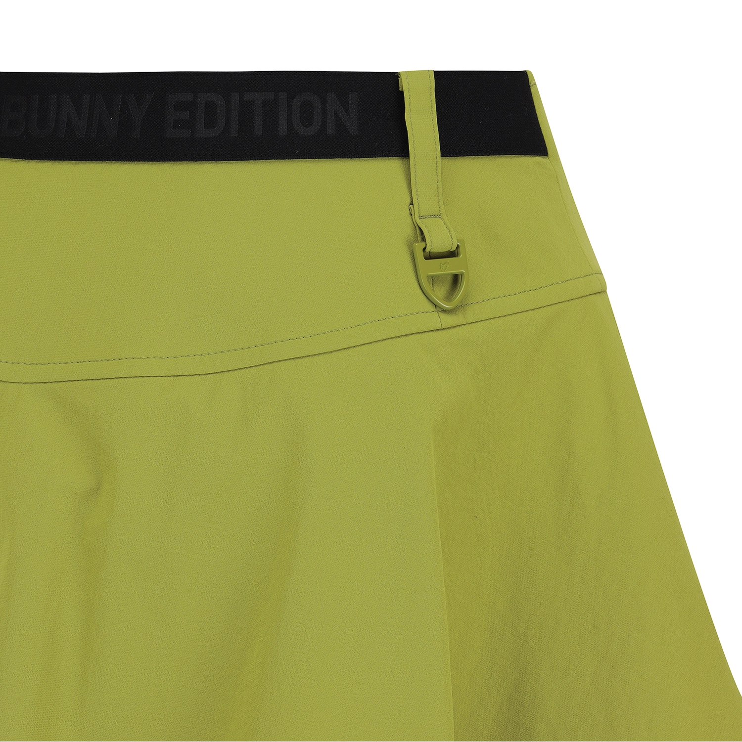Close-up of a skirt or shorts in a muted yellow-green color with a black waistband that reads 'MASTER BUNNY EDITION'.