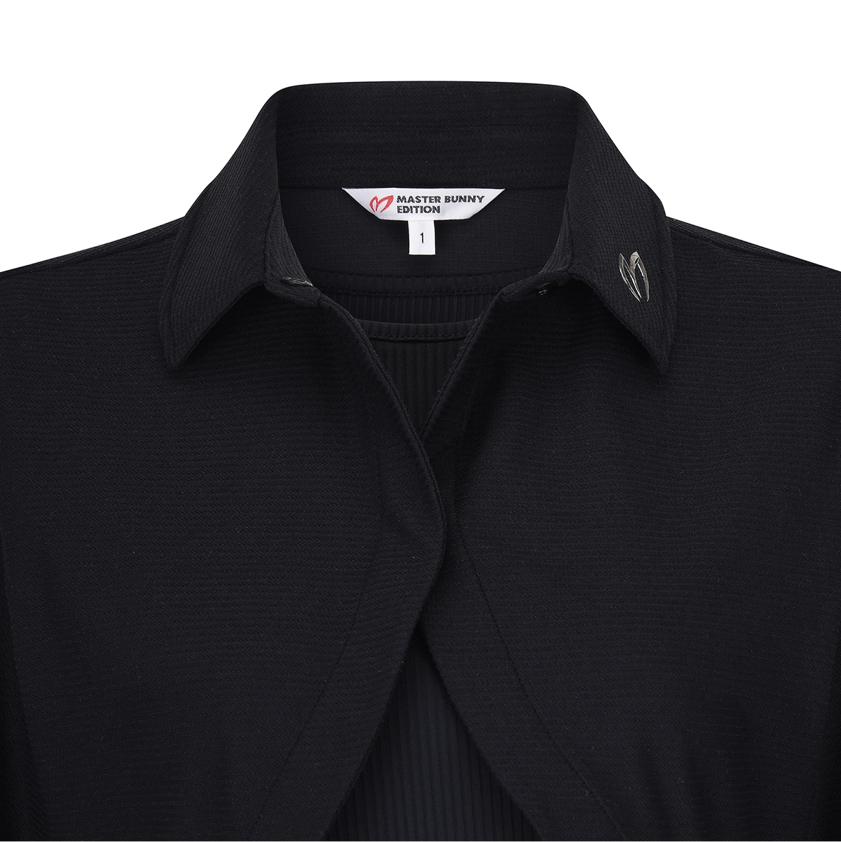 Close-up of a black ribbed knit collared shirt by Master Bunny Edition, showing the inner neck label and a small silver-toned logo on the chest.