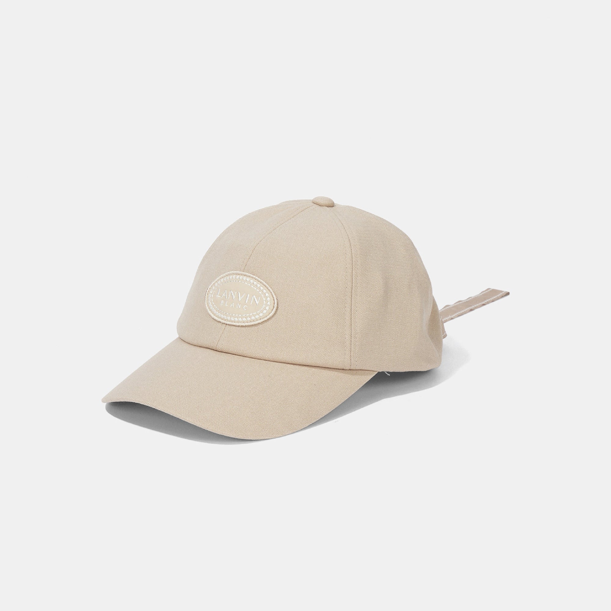 A light beige baseball cap with an oval patch on the front that reads 'LANVIN BLANC', shown on a clean white background.