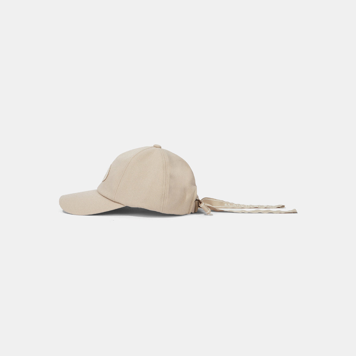A light beige baseball cap with a curved brim and matching drawstrings, shown from a side profile against a clean, light gray background.