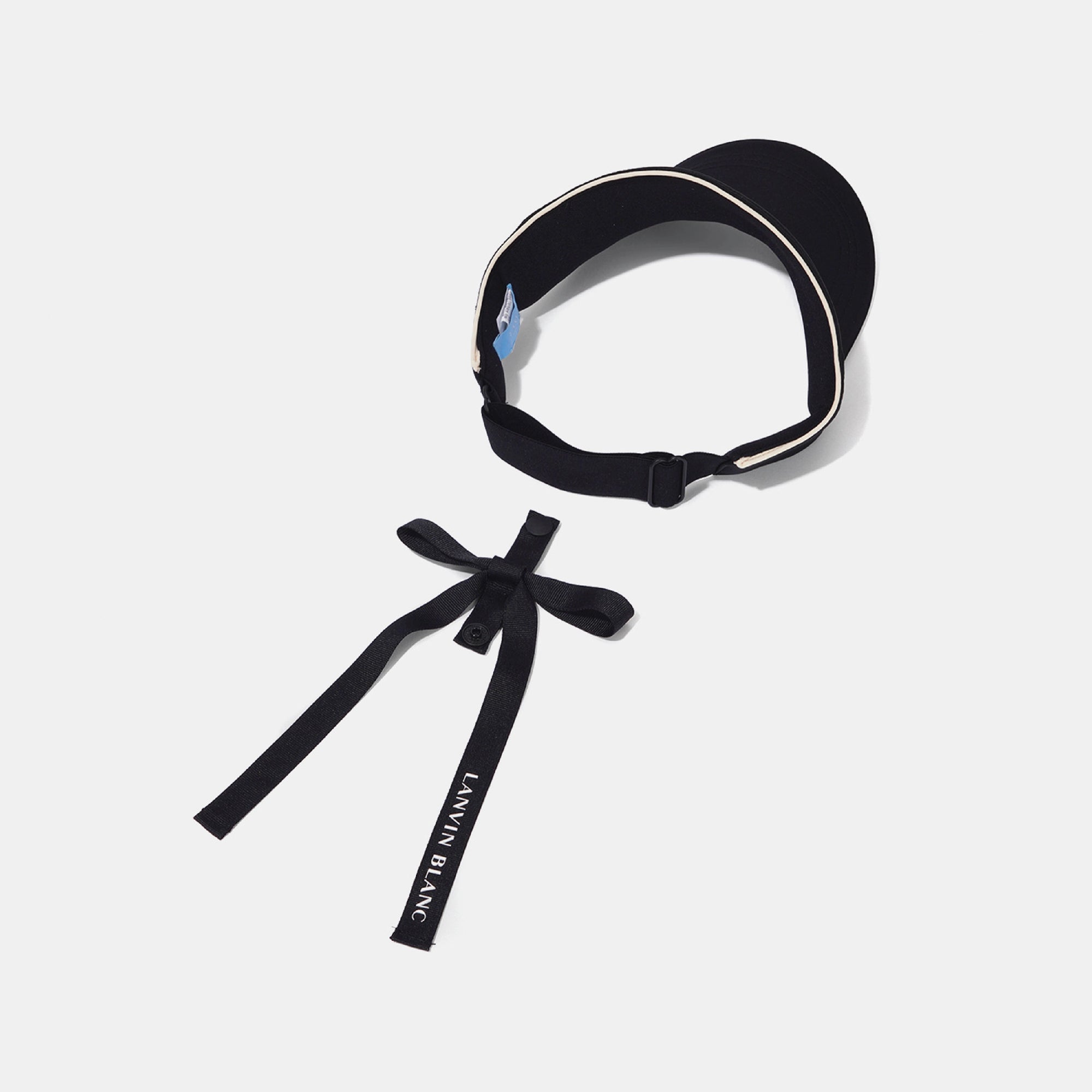 A black visor-style sun hat with a matching black chin strap tied into a bow, featuring white piping and white text reading 'LANVIN BLANC' on the strap, shown on a light gray background.