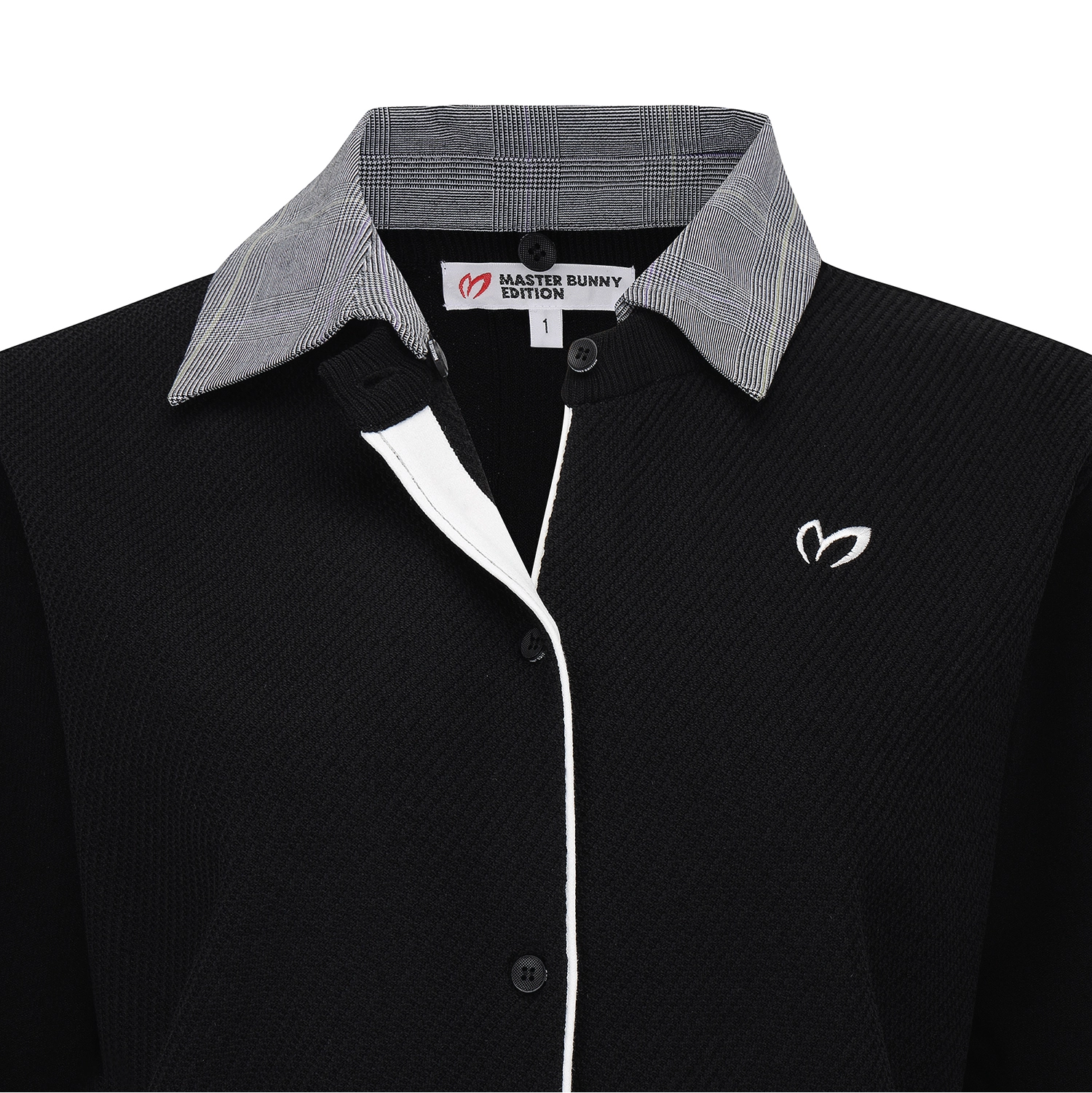 A close-up of a black ribbed knit polo shirt by Master Bunny Edition, featuring a gray and white plaid patterned collar, a white center placket, and a white embroidered logo on the chest.