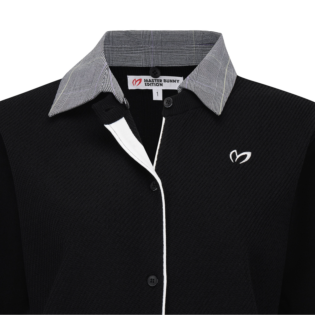 A close-up of a black ribbed knit polo shirt by Master Bunny Edition, featuring a gray and white plaid patterned collar, a white center placket, and a white embroidered logo on the chest.