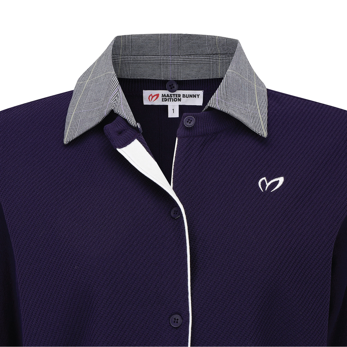 A close-up of a polo shirt collar area showing a dark purple textured body, a gray plaid inner collar, a white plaid outer collar, and a white embroidered logo on the chest.
