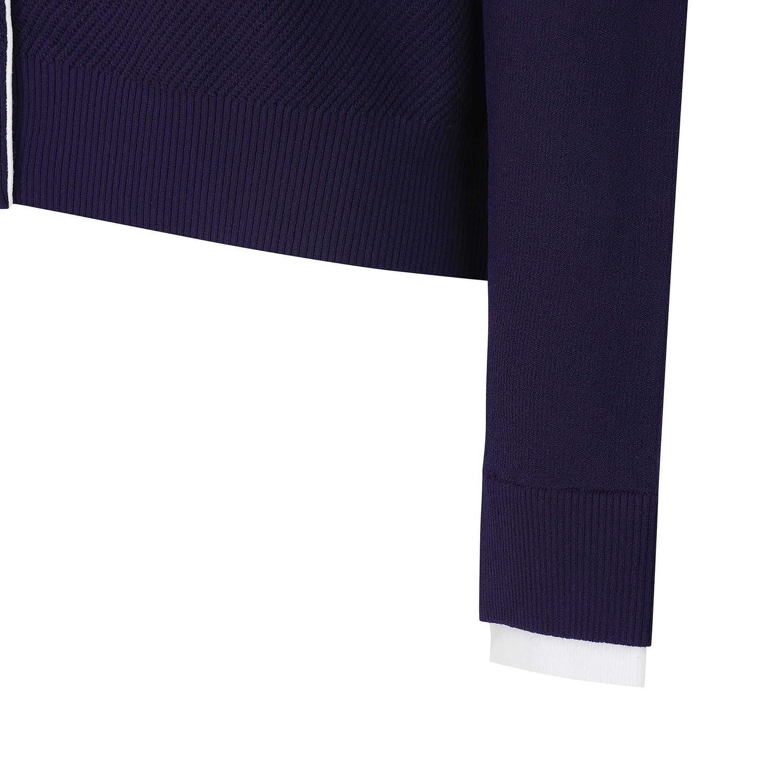Close-up detail of a ribbed knit garment, showing a dark navy sleeve cuff with a white inner layer or lining visible at the hem, against a plain white background.