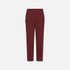 A pair of slim-fit trousers in a deep burgundy red, featuring a small black rectangular patch on the left thigh, displayed against a solid light gray background.