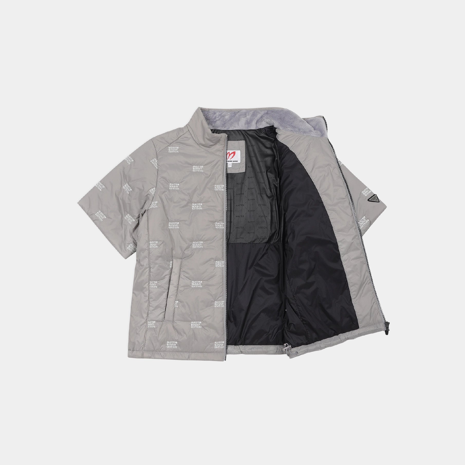 A light gray quilted jacket with an all-over tonal logo pattern, shown open to reveal a black interior lining. The jacket is laid flat against a light gray background.
