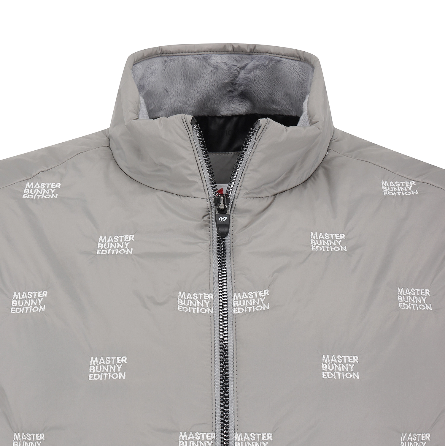 A close-up of a light gray puffer jacket with a high collar, black zipper, and an all-over white 'MASTER BUNNY EDITION' text print. The interior lining is a soft gray fleece.