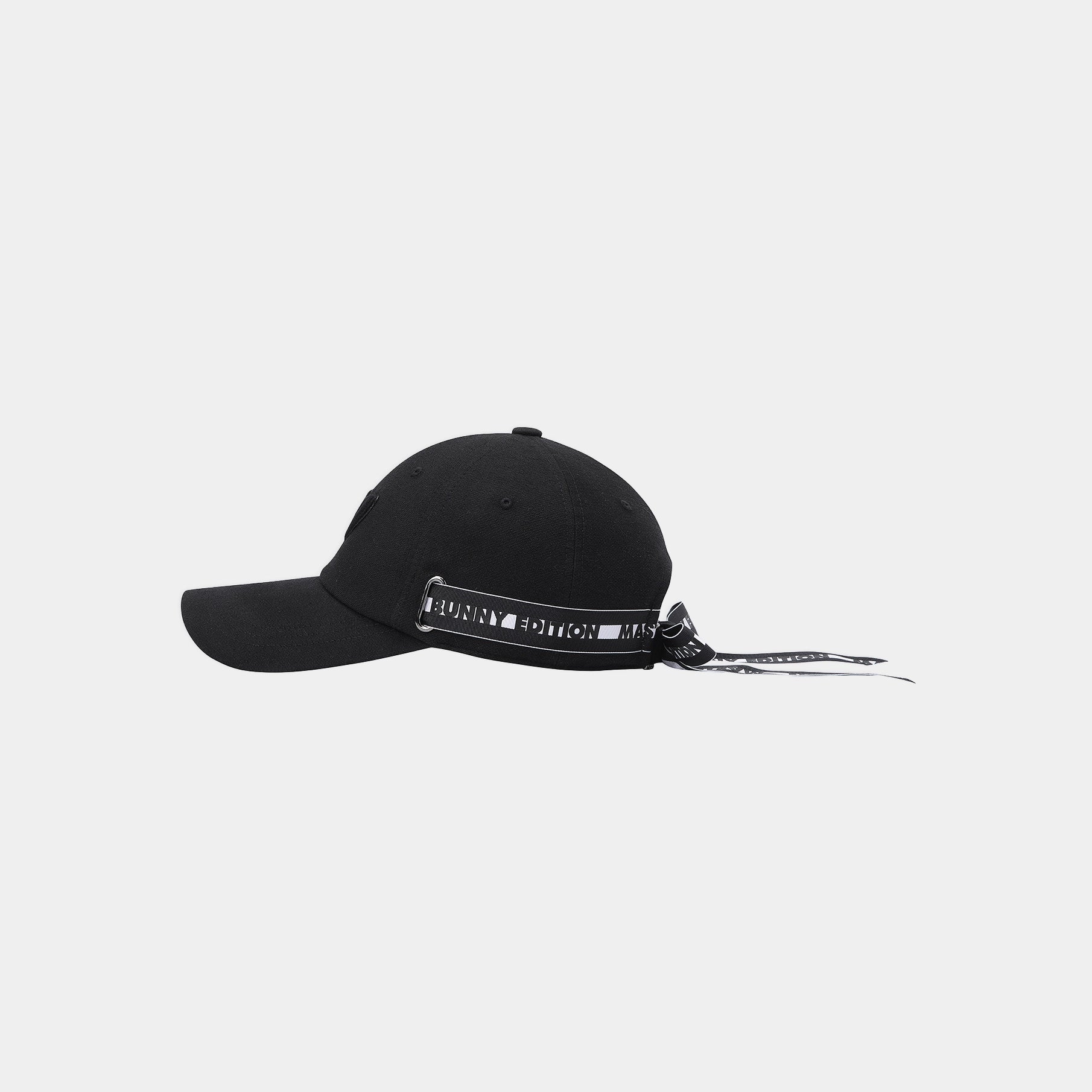 A black baseball cap with a black-and-white patterned band around the crown and matching black-and-white drawstrings, shown against a light gray background.