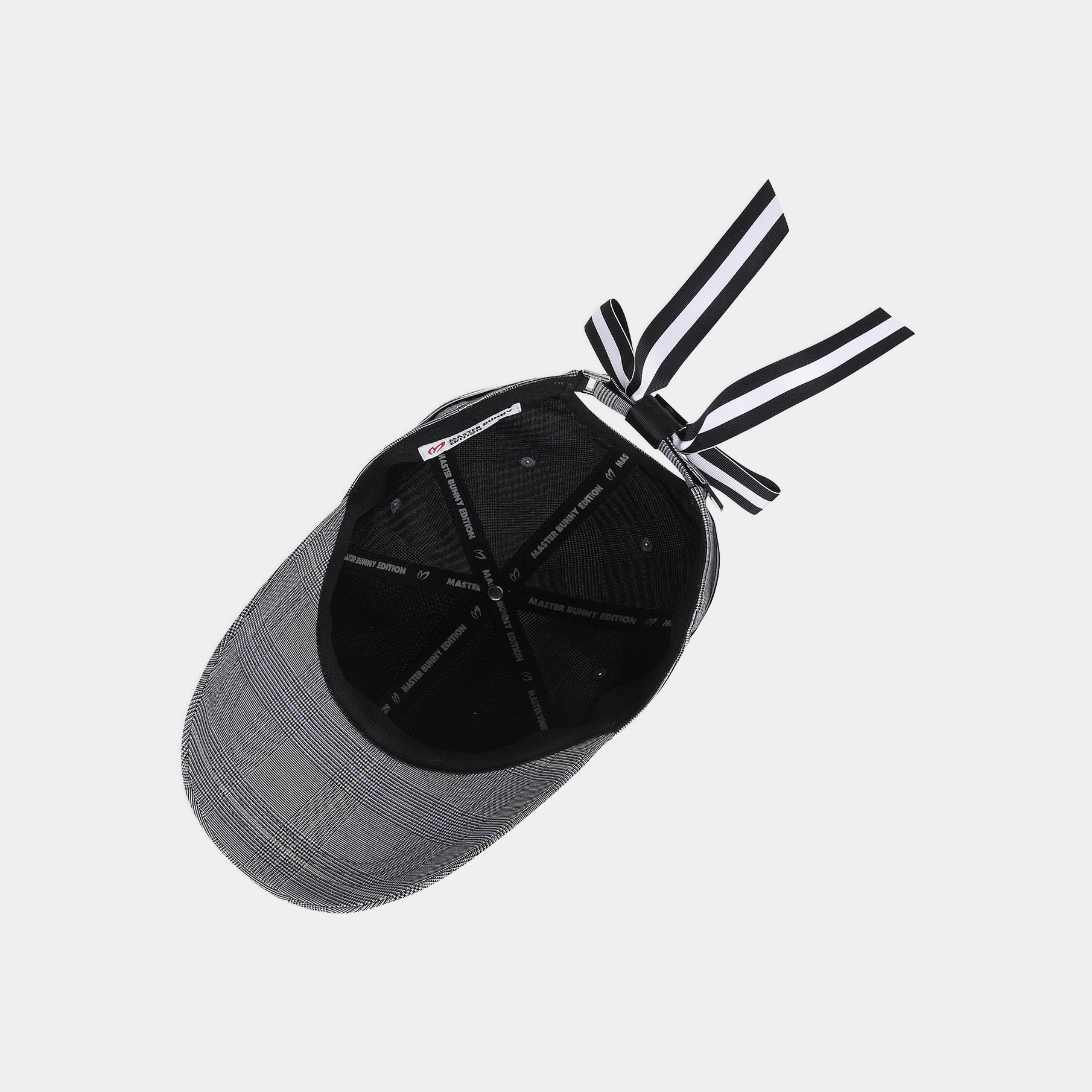A gray and black baseball cap shown from an overhead angle, featuring a black structured crown, gray plaid brim, and black-and-white striped drawstrings tied behind the back.